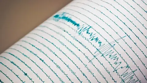 caderno registrando um gráfico, logaritmos e terremotos