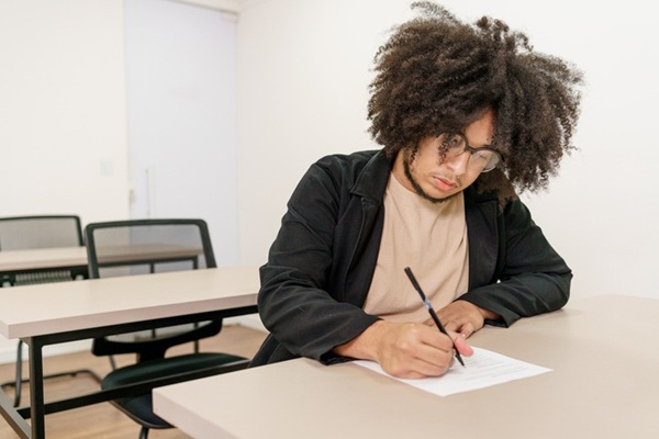 estudante escrevendo, competências redação enem